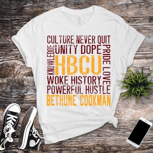 May include: White t-shirt with a maroon and gold design. The design features the words "Culture Never Quit", "Unity Dope", "HBCU", "Pride Love", "Woke History", "Powerful Hustle", and "Bethune Cookman".