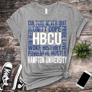 May include: Gray t-shirt with the words "CULTURE NEVER QUIT UNITY DOPE PRIDE LOVE KNOWLEDGE HBCU WOKE HISTORY POWERFUL HUSTLE HAMPTON UNIVERSITY" printed in blue on the front.