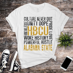 May include: White t-shirt with black and gold text that reads "Culture Never Quit Knowledge Unity Dope Pride Love HBCU Woke History Powerful Hustle Alabama State".