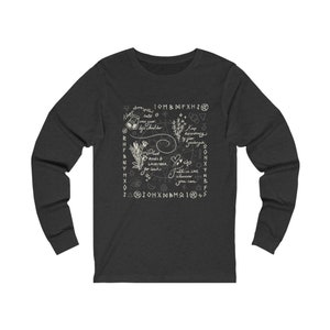 Könnte beinhalten: Ein dunkel-helles, graues Langarmshirt mit einem weißen Grafikdesign, das verschiedene Symbole zeigt, darunter ein Herz, einen Stern, einen Halbmond und eine Hand, die einen Salzstreuer hält. Die Grafik enthält auch den Text "Plant Roses & Lavender for Luck", "Keep Rosemary", "Fall in Love Whenever You Can", und "10MBMFXH10".