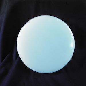 May include: A light blue round ceramic plate. The plate is smooth and has a glossy finish.