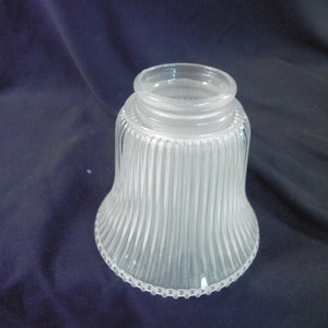 May include: A clear glass lampshade with vertical ridges and a beaded edge.