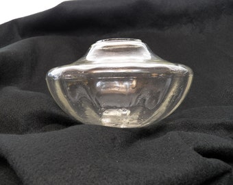 May include: A clear glass lamp shade with a rounded, bowl-like shape. The shade has a smooth, slightly textured surface.