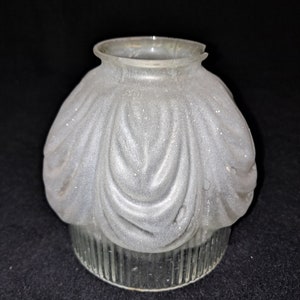 Op de afbeelding: Een matglazen lampenkap met een decoratief, geribbeld ontwerp. De kap heeft een afgeronde bovenkant en een geribbelde basis.