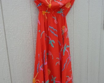 May include: A red strapless maxi dress with a colorful floral print. The dress has a fitted bodice and a flowing skirt.