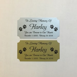 May include: Two silver and gold memorial plaques with black paw prints and the text "In Loving Memory Of Harley You are Forever in Our Hearts December 1, 2002 - February 24, 2018"