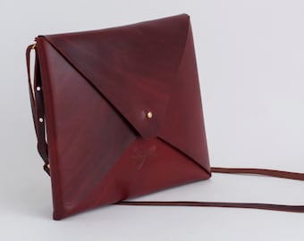 Unisex Leather bag, with rembable strap and gold button. Simple and minimalist.