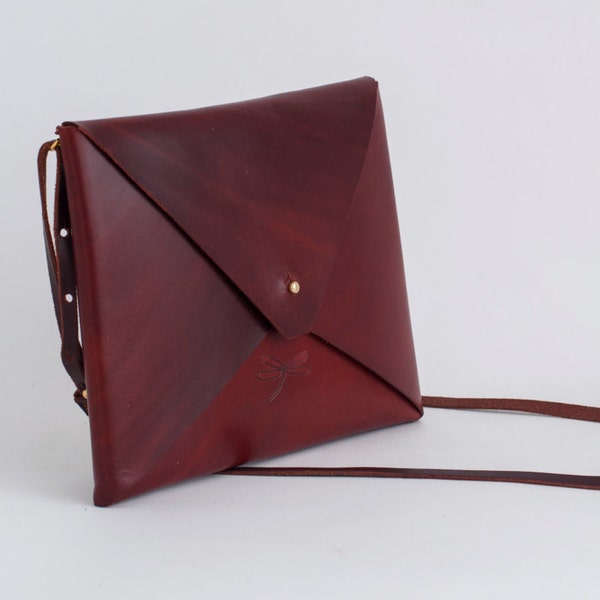 Unisex Leather bag, with rembable strap and gold button. Simple and minimalist.