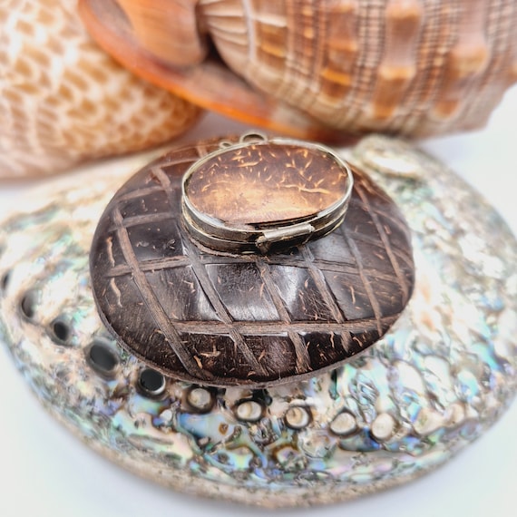 A hand-carved coconut shell box with genuine folk art detailing — the kind of tactile, organic curiosity that looks like it washed ashore from somewhere fascinating.