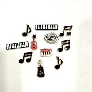 May include: A collection of black and gold musical instrument charms, including a ukulele, a violin, a keyboard, and music notes.