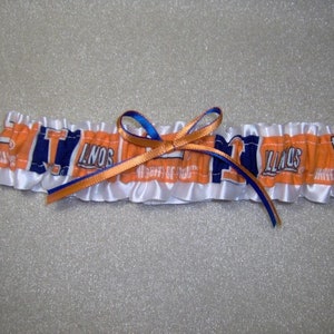 May include: White satin garter with orange and blue ribbon and a blue and orange fabric insert with the text "ILLINOIS" printed on it.