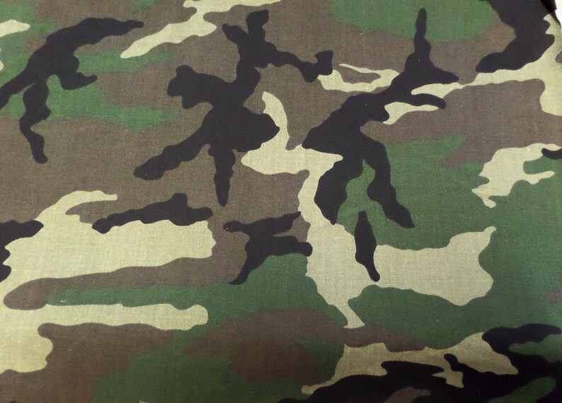 Puede incluir: Tela de camuflaje con un patr&oacute;n de formas verdes, marrones y negras.