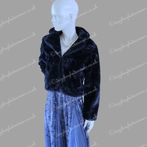 May include: A navy blue faux fur jacket with a hood, worn with a long, flowing blue skirt. The skirt features a delicate pattern and a layered design. The outfit is displayed on a mannequin. Image from dazzlingladieswear.co.uk.