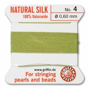 May include: A spool of natural silk thread, color number 4, with a diameter of 0.60 mm. The label reads "For stringing pearls and beads" and includes the website www.griffin.de. The thread is a light green color.