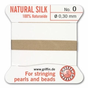 May include: A spool of natural silk thread, labeled "NATURAL SILK No. 0". The label also indicates the thread is 100% Naturseide and has a diameter of 0.30 mm. Text on the label reads "For stringing pearls and beads".