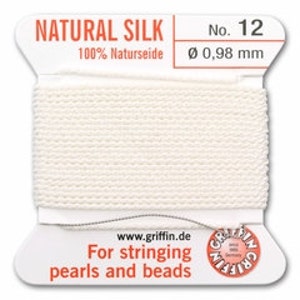 May include: A spool of natural silk thread, labeled "NATURAL SILK No. 12." The label also indicates "100% Naturseide" and a diameter of 0.98 mm. Text on the label reads "For stringing pearls and beads."