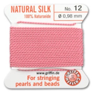 May include: A spool of pink natural silk thread, labeled "NATURAL SILK No. 12". The label also indicates "100% Naturseide" and a diameter of 0.98 mm. Text on the label reads "For stringing pearls and beads" and includes the website www.griffin.de.