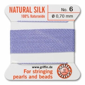 May include: A spool of light blue natural silk thread, labeled "NATURAL SILK" and "No. 6." The label indicates a diameter of 0.70 mm. Text on the label reads "For stringing pearls and beads" and includes the website www.griffin.de.