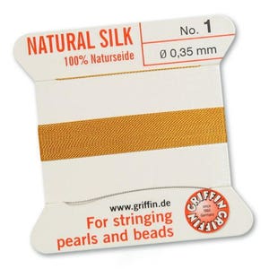 May include: A spool of natural silk thread, featuring a gold-colored thread wrapped around a white card. The card has the text "NATURAL SILK" and "For stringing pearls and beads". The thread diameter is 0.35 mm.