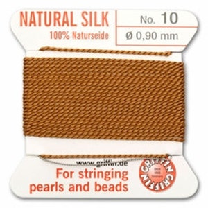 May include: A spool of natural silk thread, labeled "NATURAL SILK No. 10" with "100% Naturseide." The thread is a warm brown color, with a diameter of 0.90 mm. Text on the label reads "For stringing pearls and beads."