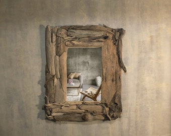 May include: A rustic wooden mirror with a unique, natural frame made from driftwood. The mirror reflects a room with a couch, chair, and a small table.