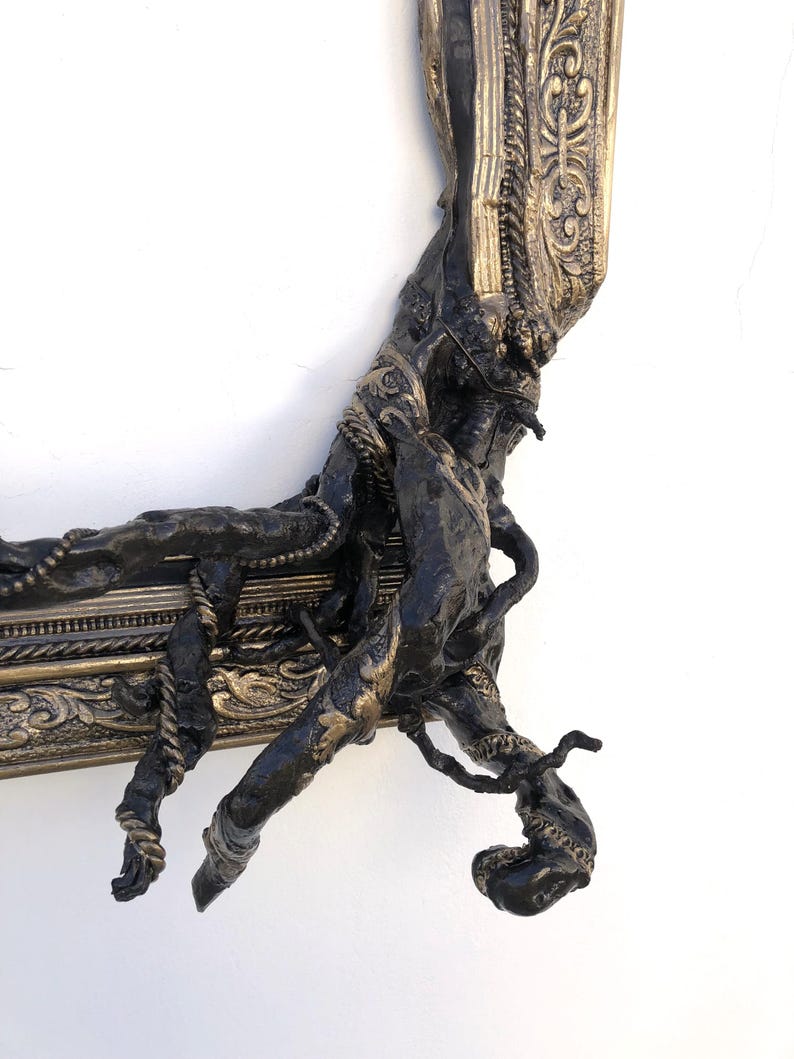 May include: An ornate picture frame in dark bronze with gold highlights. The frame has a textured, organic design with twisted elements and intricate detailing, creating a unique, artistic aesthetic.