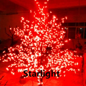 May include: A red lighted cherry blossom tree with white lights. The tree is lit up and the lights are twinkling. The tree is on a black base and the word "Starlight" is visible in the image.