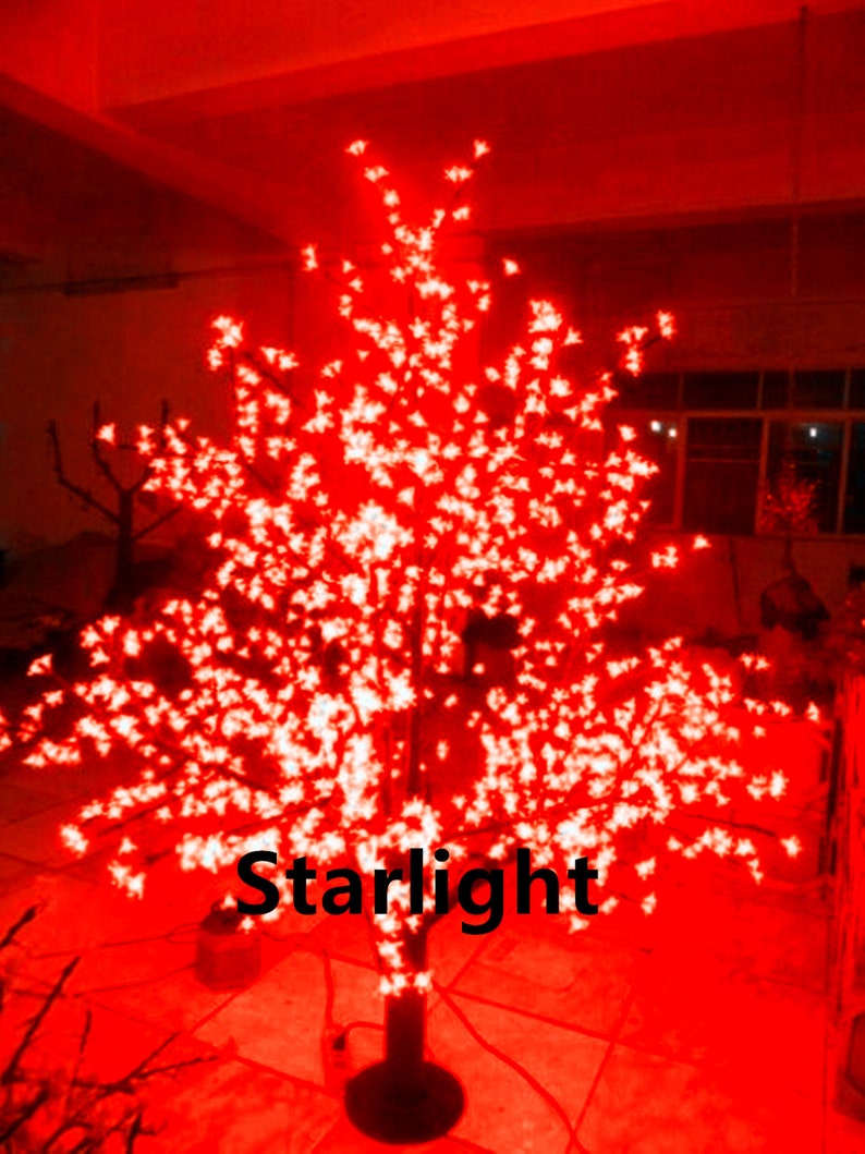 May include: A red lighted cherry blossom tree with white lights. The tree is lit up and the lights are twinkling. The tree is on a black base and the word "Starlight" is visible in the image.