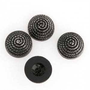 May include: Four black buttons with a rope-like design and a single black button with a smooth surface.
