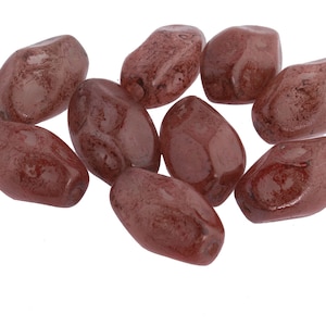 May include: A group of eight smooth, oval-shaped, red-brown glass beads. The beads have a mottled, marbled appearance.