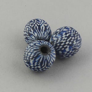 Peut inclure: Trois perles rondes avec un motif bleu et blanc. Les perles ont une couleur de base bleu foncé avec un motif tacheté blanc. Une perle a un grand trou au centre.