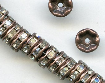 May include: A strand of copper-toned beads with clear rhinestones. The beads are round and have a wavy design. Two individual beads are shown separately.