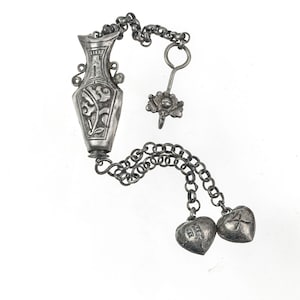 Antique Chinese Qing Dynasty silver repoussé needle case with charms and chatelaine clip. pdvs1009
