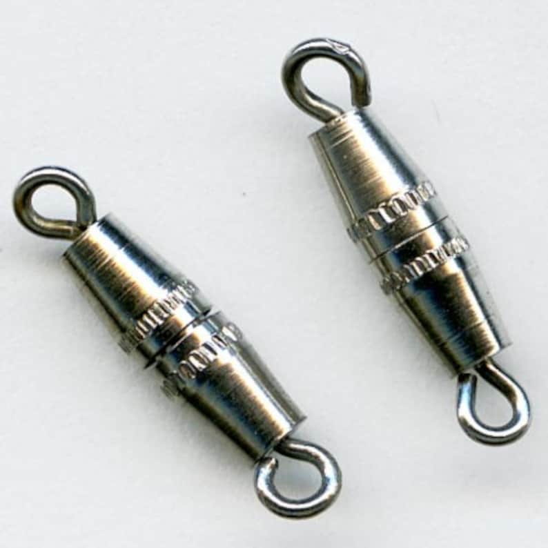 May include: Two silver-toned metal clasps with a loop on each end. The clasps are designed to connect two strands of beads or other jewelry.
