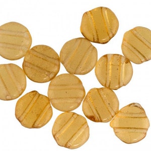 May include: A group of 10 round, translucent, amber-coloured glass beads with a striped pattern. The beads are approximately 2.5 cm in diameter.