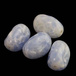 May include: Four smooth, light blue and white marbled oval-shaped beads. The beads have a cloudy, swirled pattern.