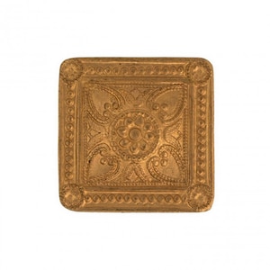 May include: A square gold-colored metal plaque with a raised, intricate design. The design features a central flower with four surrounding leaves, all surrounded by a border of small circles.