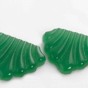 May include: Two green glass shell-shaped buttons with a textured surface.