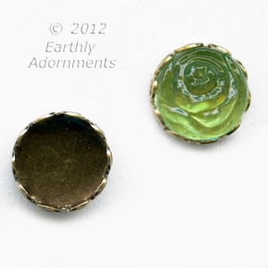 May include: Two round, decorative buttons. One button is gold with a scalloped edge. The other button is green glass with a raised, floral design and a gold scalloped edge.