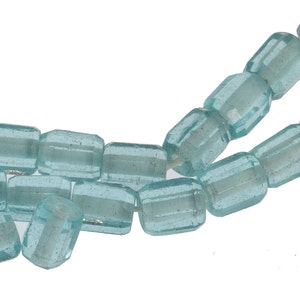 May include: A strand of light blue glass beads with a faceted, rectangular shape.