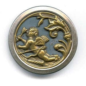 May include: A gold-toned button with a blue background featuring a cherub holding an arrow and a bow. The cherub is surrounded by a decorative floral design.