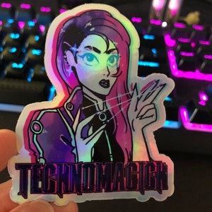 May include: A holographic sticker featuring a cartoon woman with purple hair, wearing a black jacket and holding a glowing orb. The sticker has the text "TECHNOMAGICK" printed on the bottom.