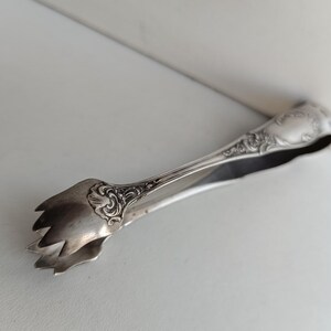 Small French Art Nouveau with Empire styling silver plated claw tongs with for serving sugar / olives tongs with makers stamp.
