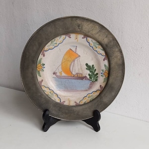 Vintage / antique pewter plate with ceramic insert depicting a sail boat, with pewter stamps and labels.