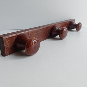 Retro French vintage 3 peg coat rack / coat hooks in solid wood with glossy brown finish, circa 1970s.