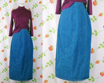 May include: A long denim skirt with vertical seams. The skirt is a dark blue color and has a straight silhouette.
