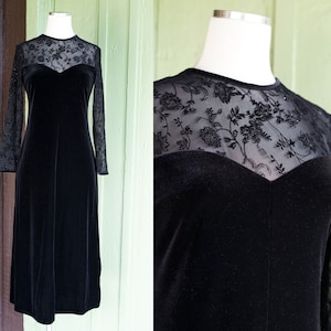 May include: A black velvet dress with a sheer lace overlay. The dress has long sleeves and a sweetheart neckline.
