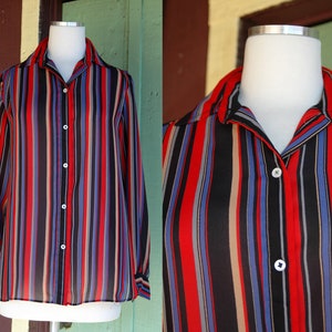 May include: A long-sleeved button-up shirt with vertical stripes in red, blue, black, and beige.