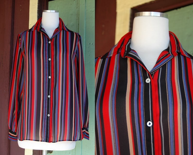 May include: A long-sleeved button-up shirt with vertical stripes in red, blue, black, and beige.