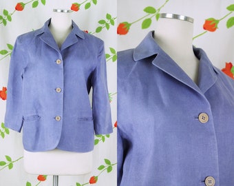 Puede incluir: Una chaqueta de lino azul claro con cuello de muesca y cierre de tres botones. La chaqueta tiene dos bolsillos delanteros y mangas largas.